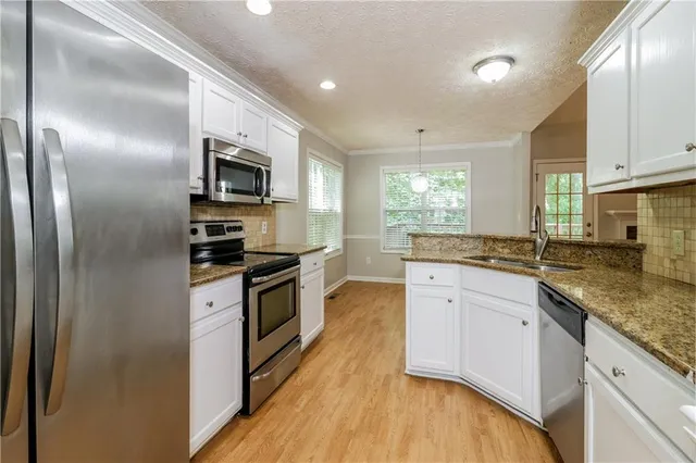 a kitchen with stainless steel appliances granite countertop a stove a sink and a refrigerator