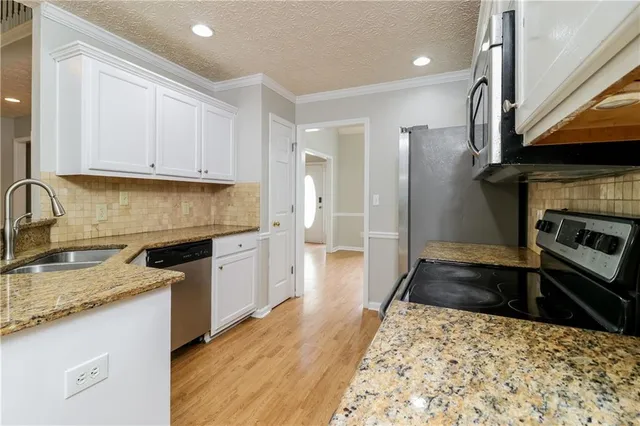 a kitchen with granite countertop a sink stove and refrigerator
