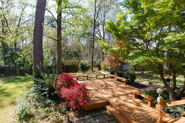 a view of a backyard with table and chairs and a large tree