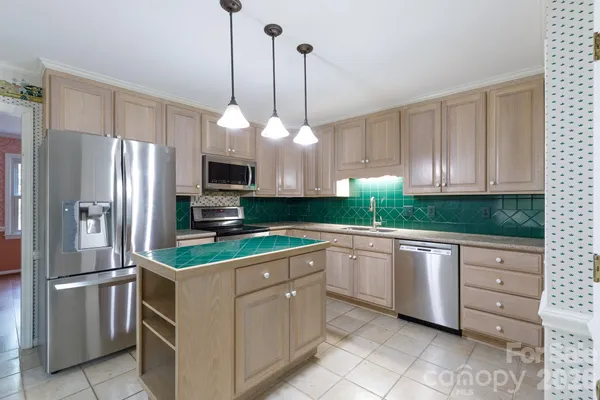 a kitchen with stainless steel appliances granite countertop a refrigerator and a sink