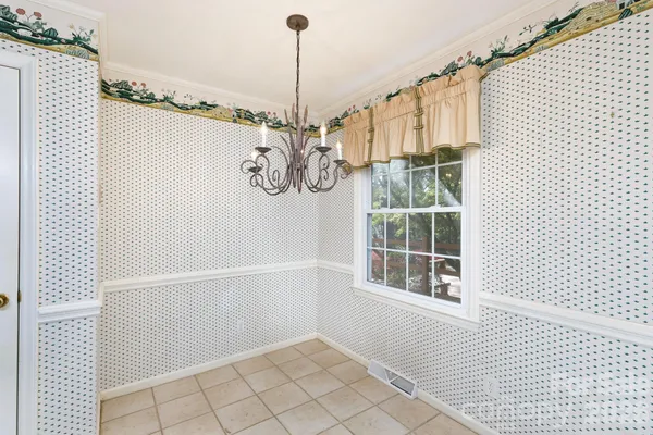 an empty room with wooden floor fireplace and windows