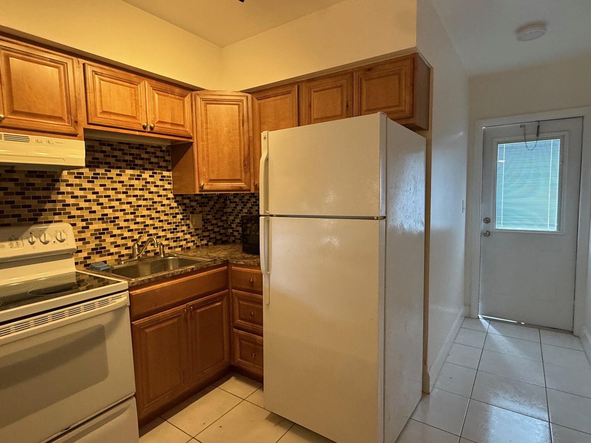 3850 Northeast 21st Way, Unit 53 Lighthouse Point, FL 33064 - Photo 5 of 18 a kitchen with stainless steel appliances a refrigerator and a stove top oven