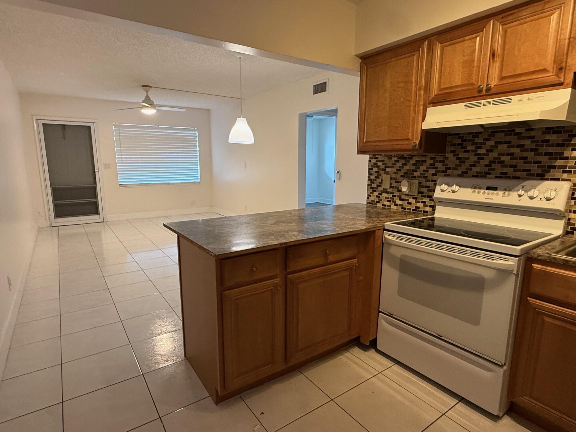 3850 Northeast 21st Way, Unit 53 Lighthouse Point, FL 33064 - Photo 6 of 18 a kitchen with granite countertop a sink and a stove