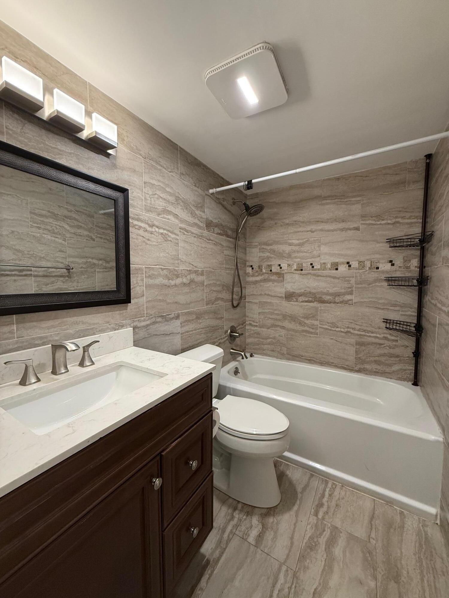 3850 Northeast 21st Way, Unit 53 Lighthouse Point, FL 33064 - Photo 9 of 18 a bathroom with a sink a toilet a mirror and bathtub