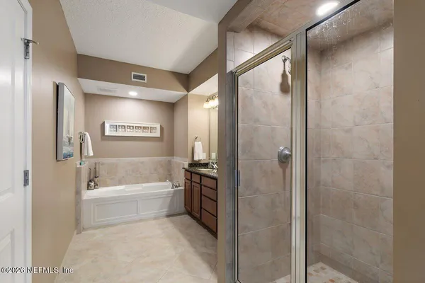 a bathroom with a tub shower and sink
