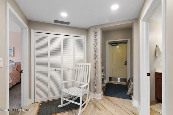 a view of a hallway with bathroom and wooden floor