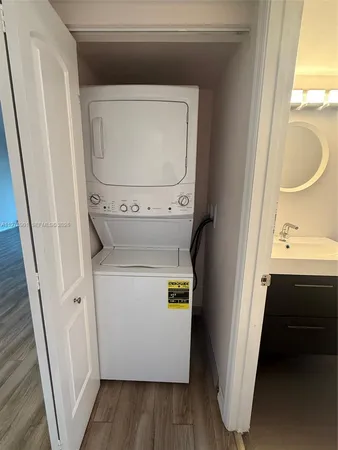 a utility room with wooden floor washer and dryer