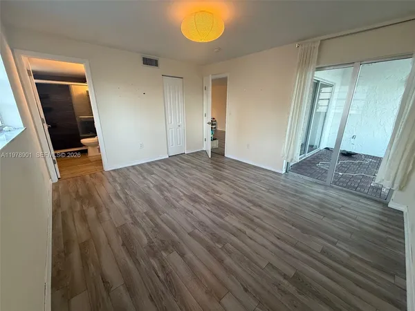 a view of empty room with wooden floor