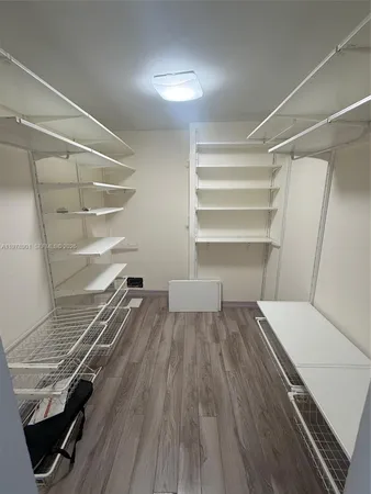 a view of walk in closet with empty racks