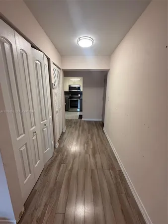 a view of a room with wooden floor electronic appliances and stairs