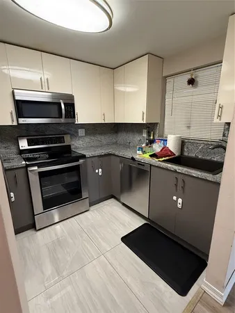a kitchen with a sink a stove and cabinets