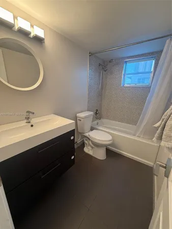 a bathroom with a double vanity sink toilet and a mirror
