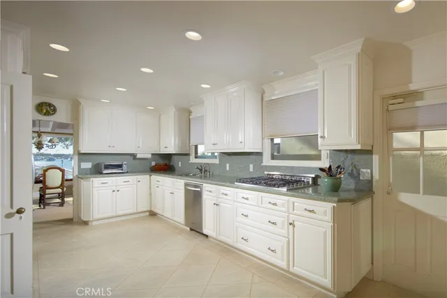 a large white kitchen with a white stove top oven and cabinets