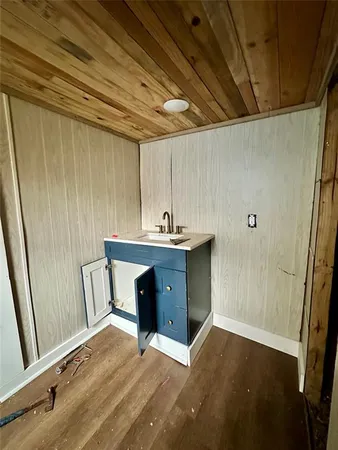 a hallway with a sink a mirror and a wooden roof