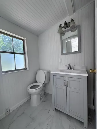 a bathroom with a toilet sink and mirror