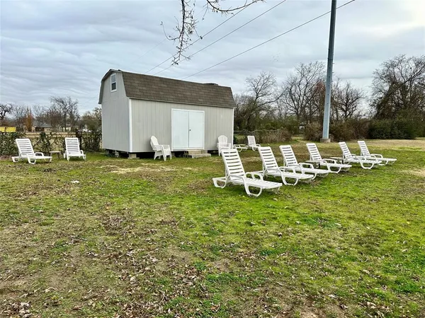 a couple of lawn chairs sitting in backyard of house