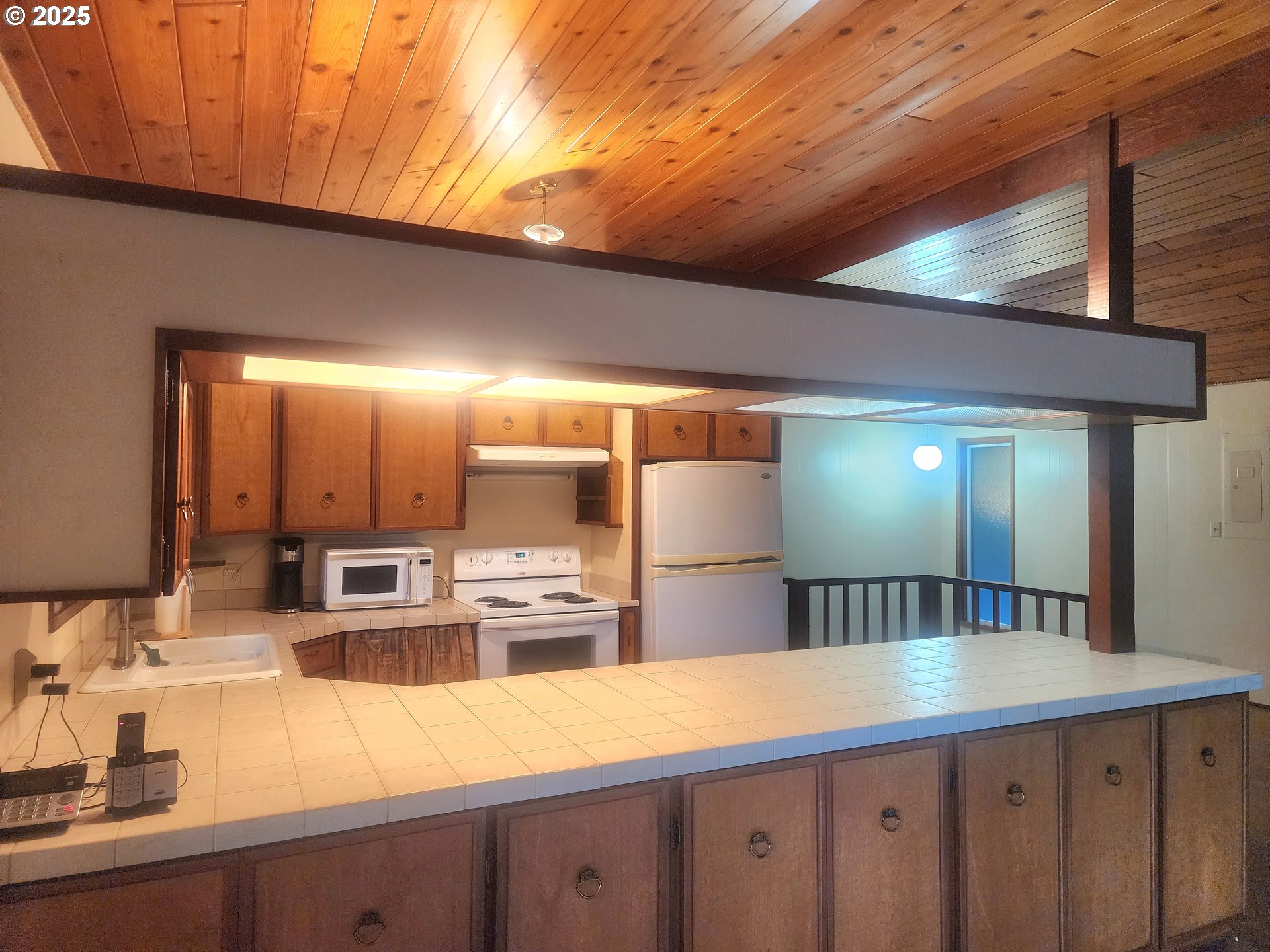 96015 Sun Lake Lane Lakeside, OR 97449 - Photo 16 of 46 a kitchen with stainless steel appliances kitchen island granite countertop a sink and cabinets