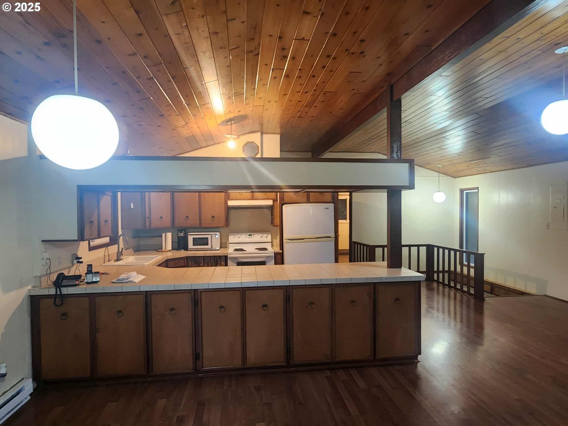 96015 Sun Lake Lane Lakeside, OR 97449 - Photo 29 of 46 a dining hall with stainless steel appliances granite countertop a stove a sink dishwasher and cabinets with wooden floor
