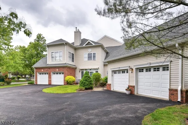 a view of a white house with a small yard and a large tree