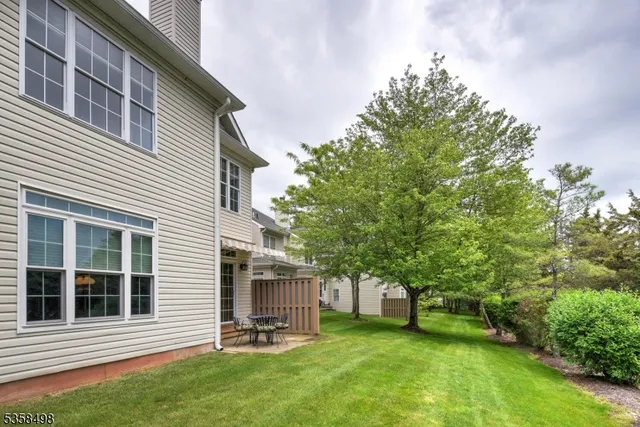 a view of a backyard with table and chairs and a tree