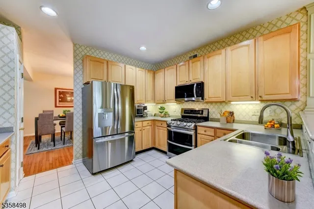 a kitchen with granite countertop a refrigerator and a stove top oven