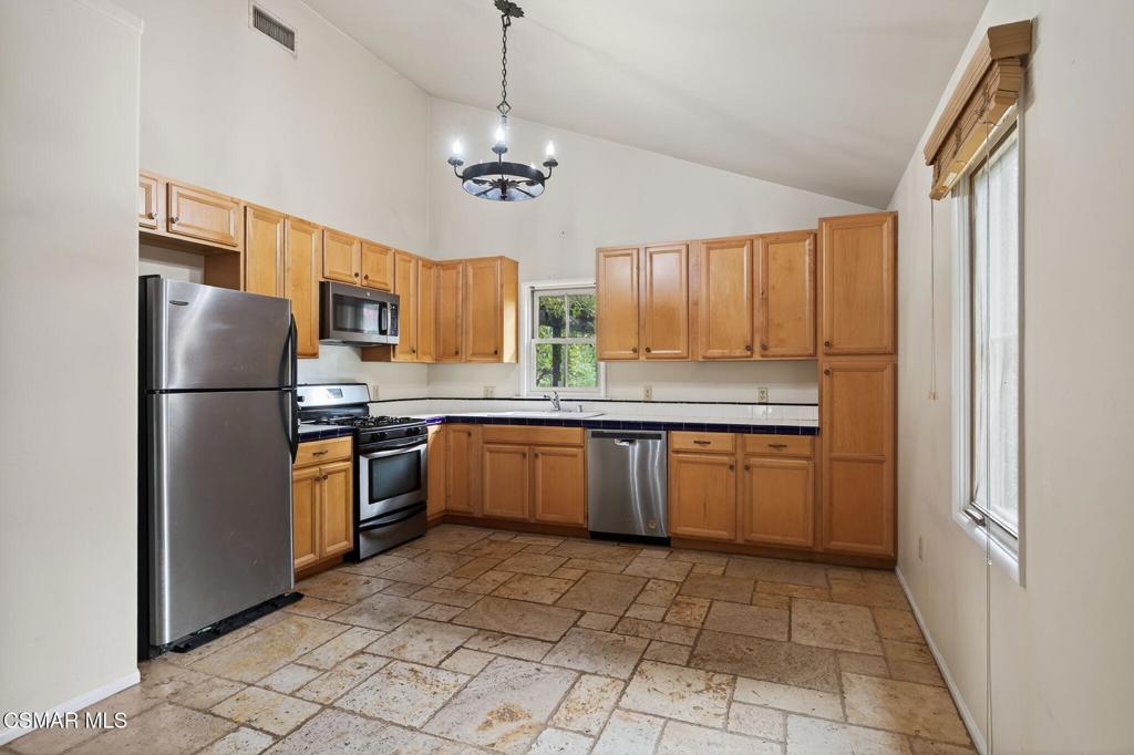 1560 Goodenough Road Fillmore, CA 93015 - Photo 46 of 76 a kitchen with stainless steel appliances granite countertop a refrigerator a sink dishwasher a stove with wooden cabinets