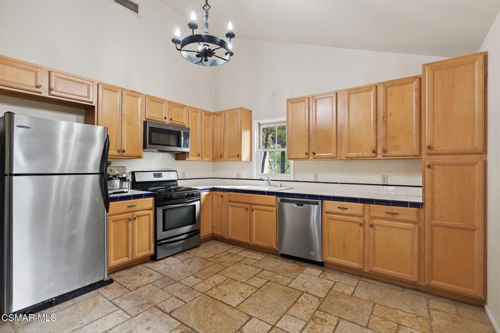 1560 Goodenough Road Fillmore, CA 93015 - Photo 48 of 76 a kitchen with stainless steel appliances granite countertop a refrigerator a stove a sink dishwasher and a microwave