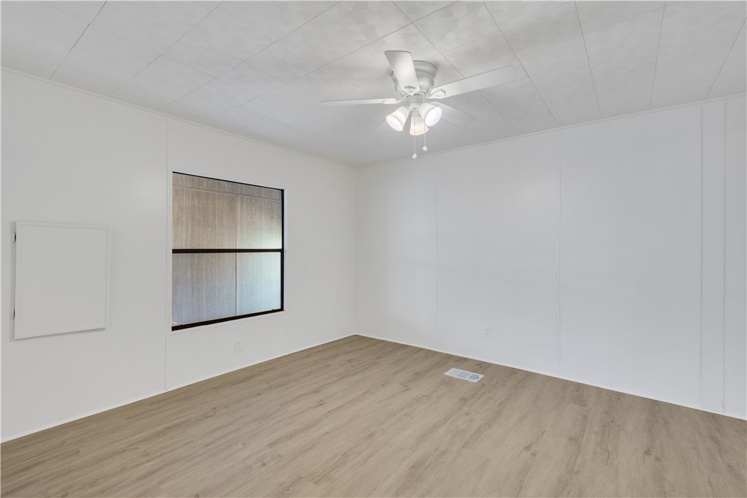 908 Oleander Circle Sebastian, FL 32976 - Photo 15 of 36 an empty room with wooden floor chandelier fan and windows