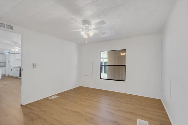 an empty room with windows and fan