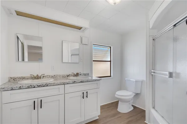 a bathroom with a toilet sink and mirror