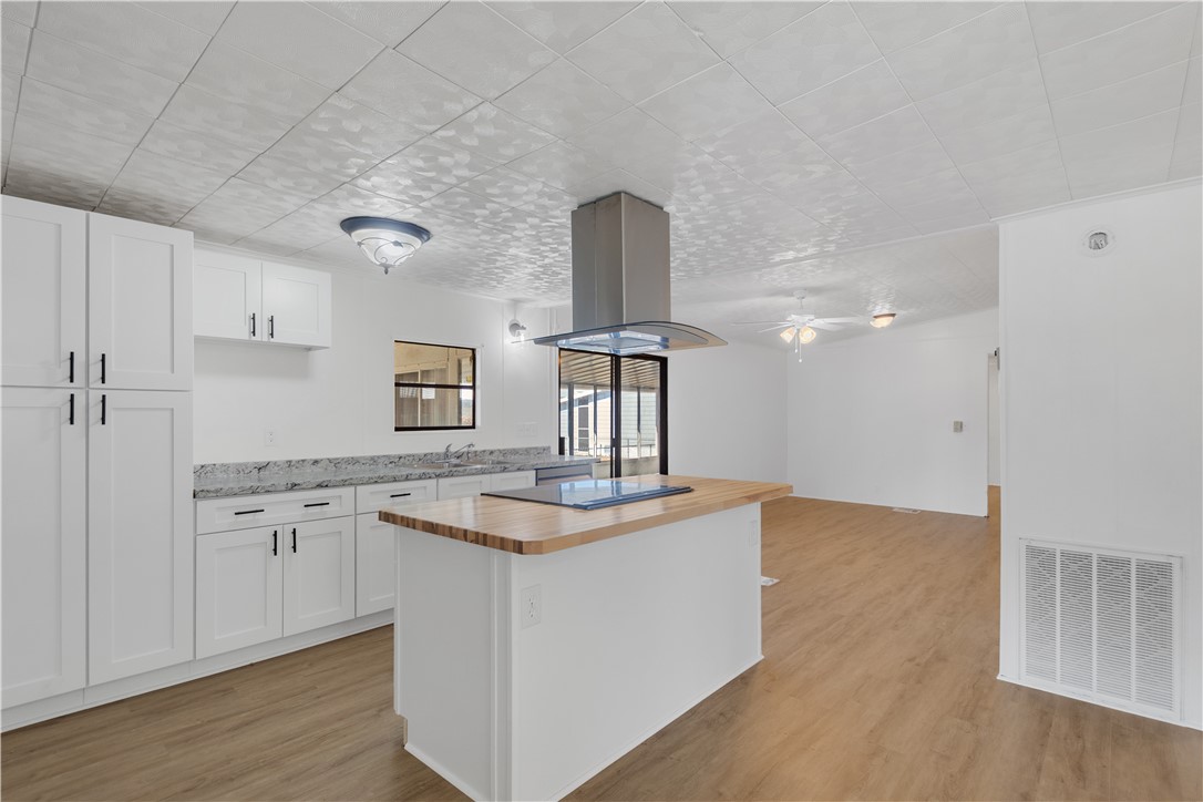 908 Oleander Circle Sebastian, FL 32976 - Photo 7 of 36 a kitchen with kitchen island granite countertop a sink cabinets and wooden floor