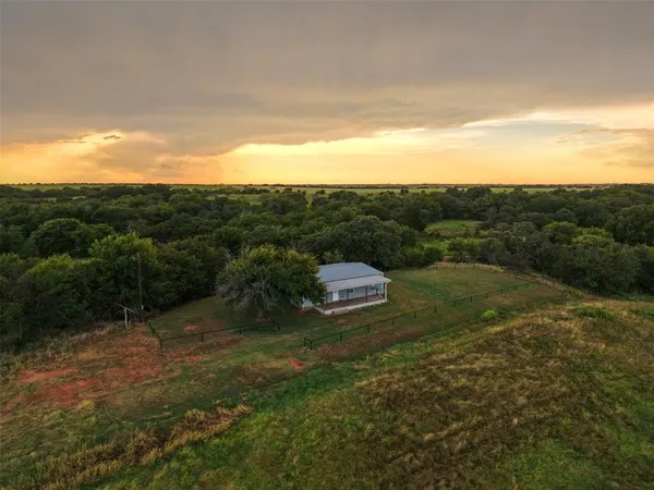 a view of a dry yard with green space