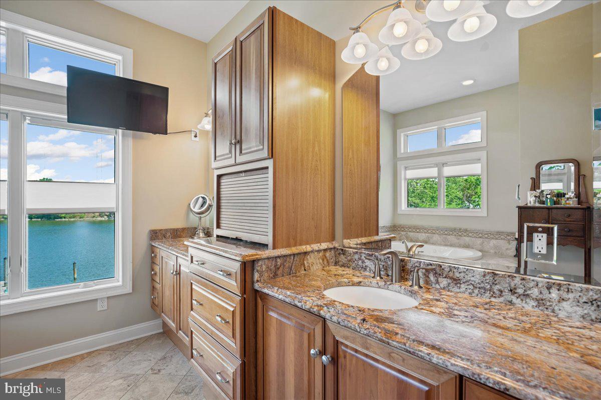 45216 Clarkes Landing Road Hollywood, MD 20636 - Photo 33 of 81 a bathroom with a granite countertop sink a large mirror and a window
