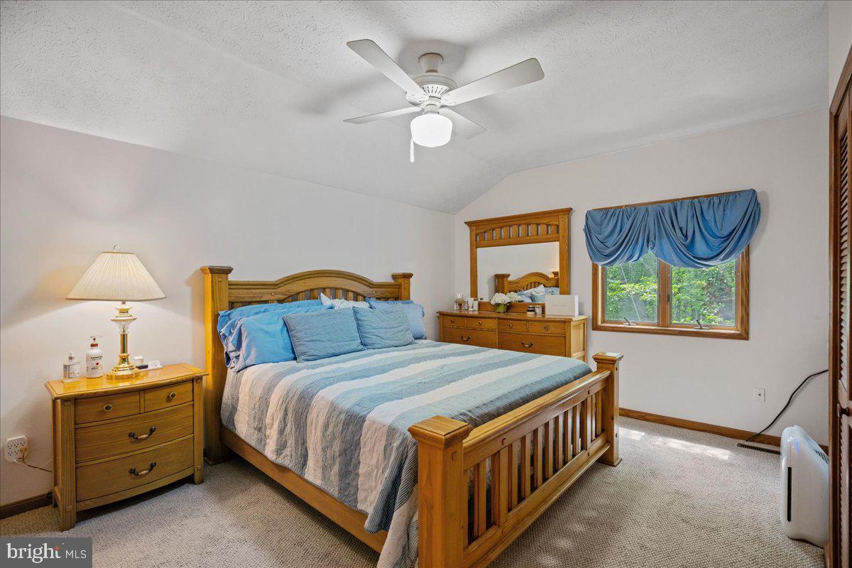 45216 Clarkes Landing Road Hollywood, MD 20636 - Photo 72 of 81 a bedroom with a bed and a chandelier