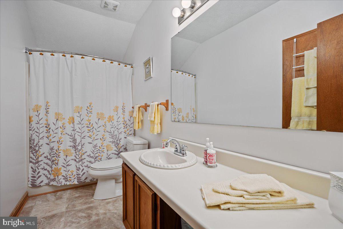 45216 Clarkes Landing Road Hollywood, MD 20636 - Photo 75 of 81 a bathroom with a granite countertop sink a mirror and shower curtain