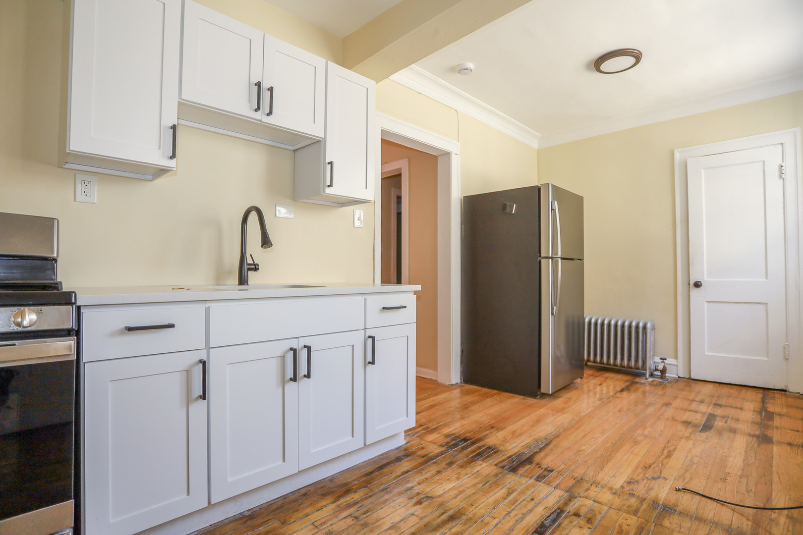 4019 West School Street, Unit 2E Chicago, IL 60641 - Photo 2 of 8 a kitchen with a refrigerator sink and cabinets
