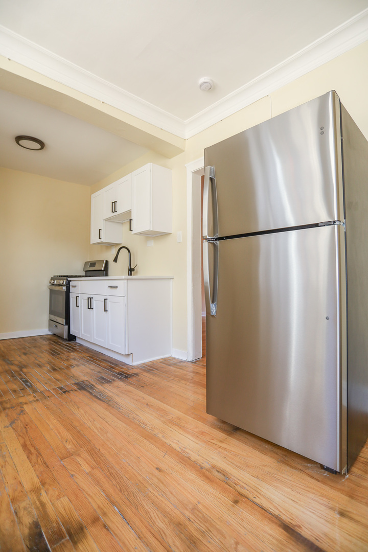 4019 West School Street, Unit 2E Chicago, IL 60641 - Photo 4 of 8 a kitchen with granite countertop a refrigerator and a sink