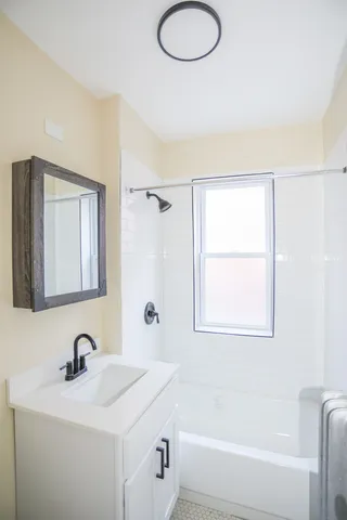 a bathroom with a tub sink and mirror