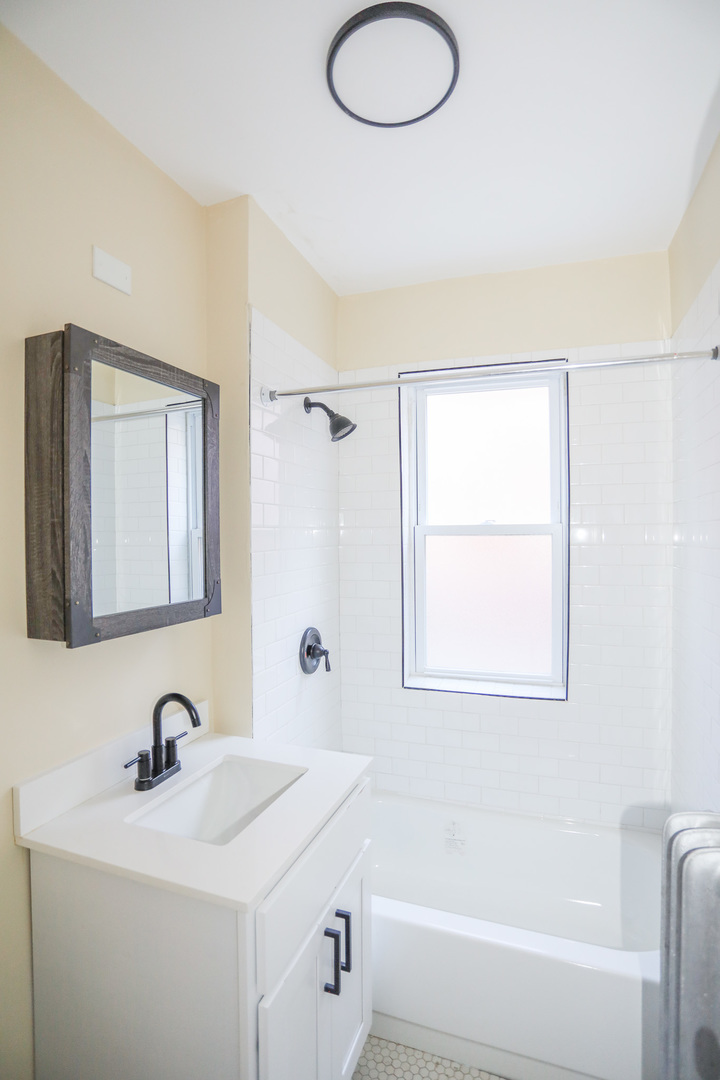 4019 West School Street, Unit 2E Chicago, IL 60641 - Photo 5 of 8 a bathroom with a tub sink and mirror