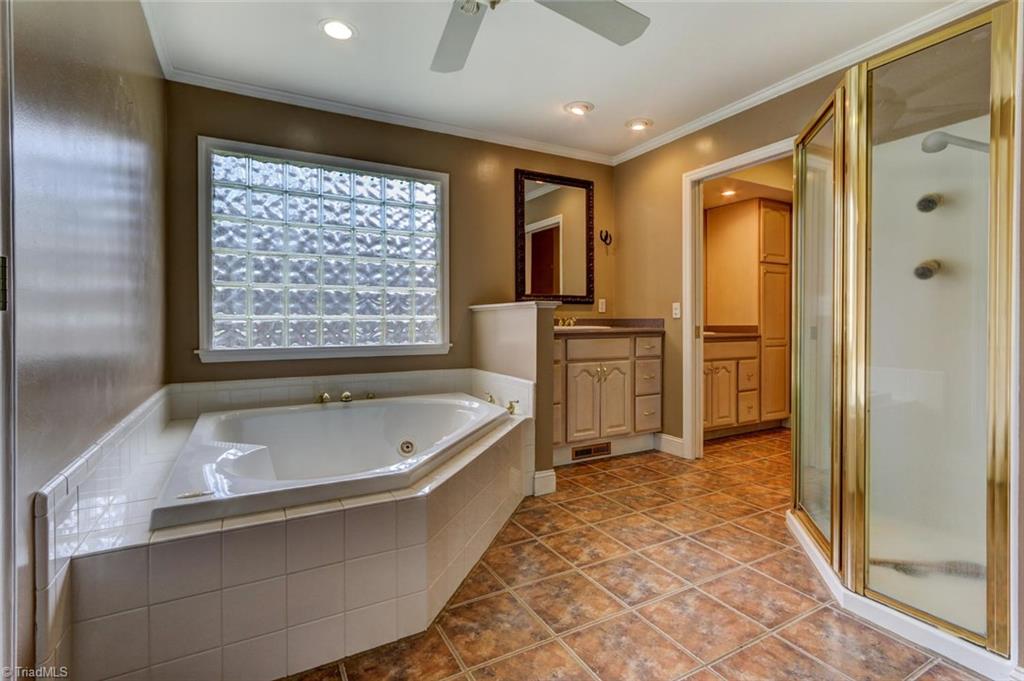 647 Simpson-Calhoun Road Greensboro, NC 27455 - Photo 15 of 30 The master bath has a jetted tub with privacy glass window, separate shower, HUGE closet, tile floor and dual vanities. The second vanity is past of the adjoining half bath.