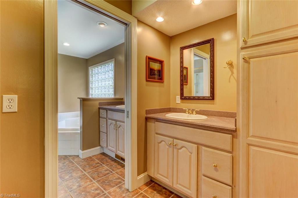 647 Simpson-Calhoun Road Greensboro, NC 27455 - Photo 16 of 30 Adjoining with a pocket door, the half bath features a linen cabinet.