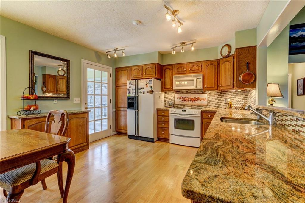 647 Simpson-Calhoun Road Greensboro, NC 27455 - Photo 8 of 30 Another view of the kitchen. The granite is high end with lots of movement in the stone. The backsplash features your four legged friends!
