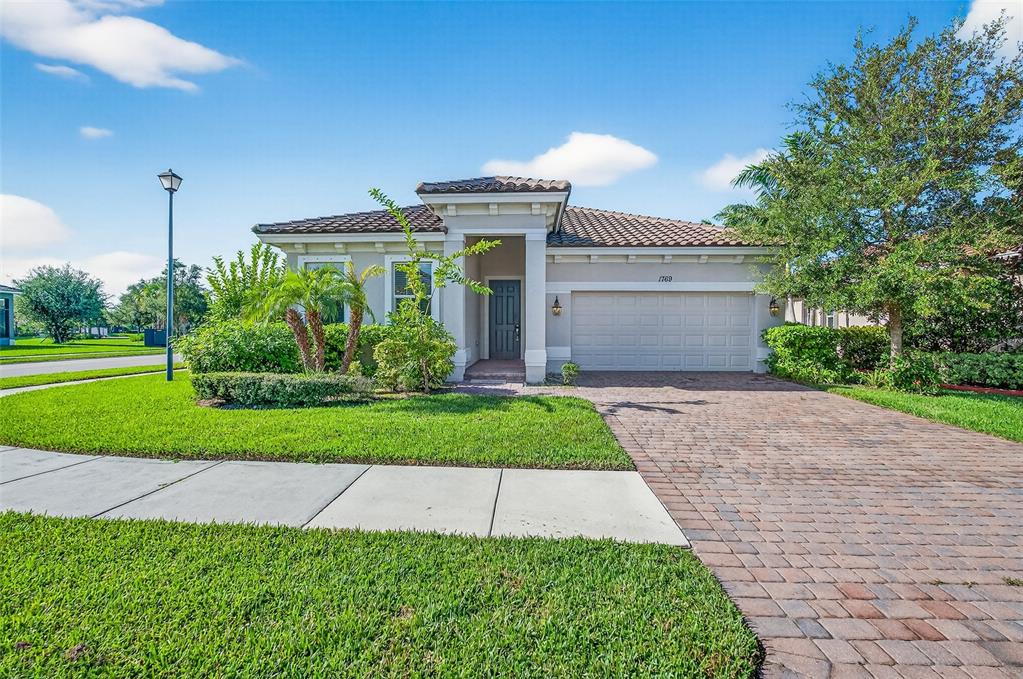 a front view of a house with a yard and potted plants