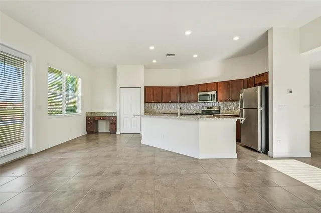 a view of kitchen with stainless steel appliances refrigerator oven sink and cabinets