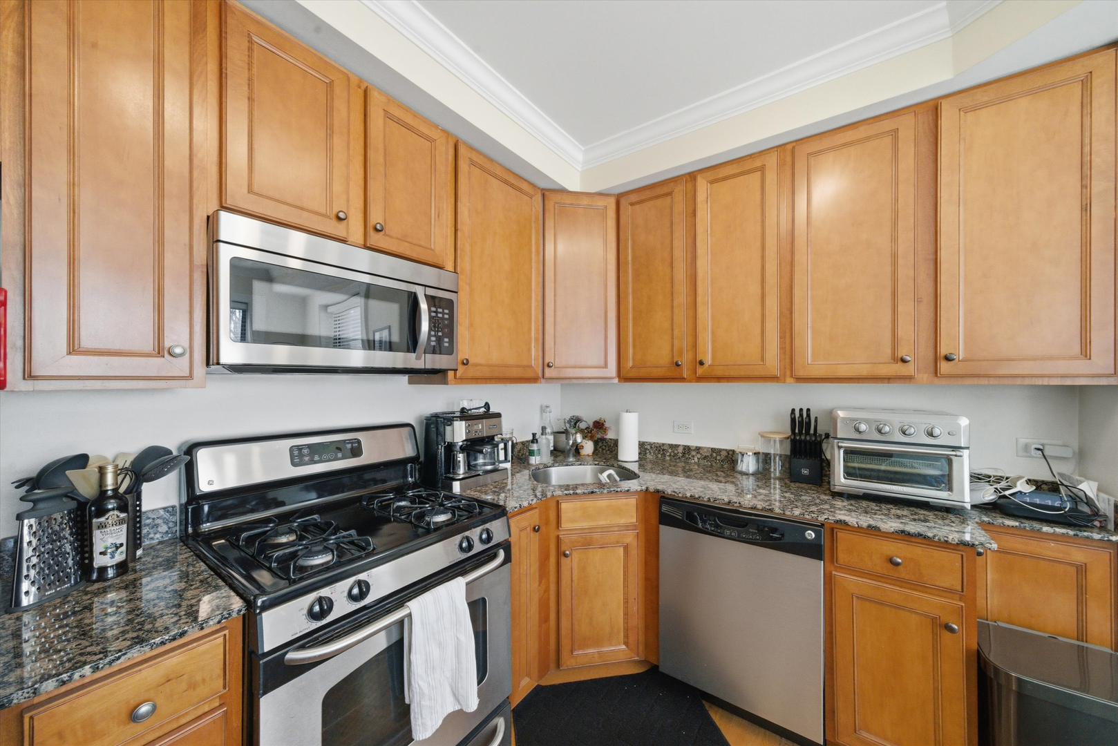 548 West Deming Place, Unit 1 Chicago, IL 60614 - Photo 2 of 11 a kitchen with granite countertop cabinets stainless steel appliances and a sink