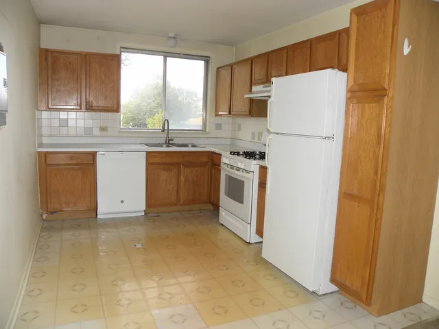 a kitchen with a refrigerator sink stove and cabinets