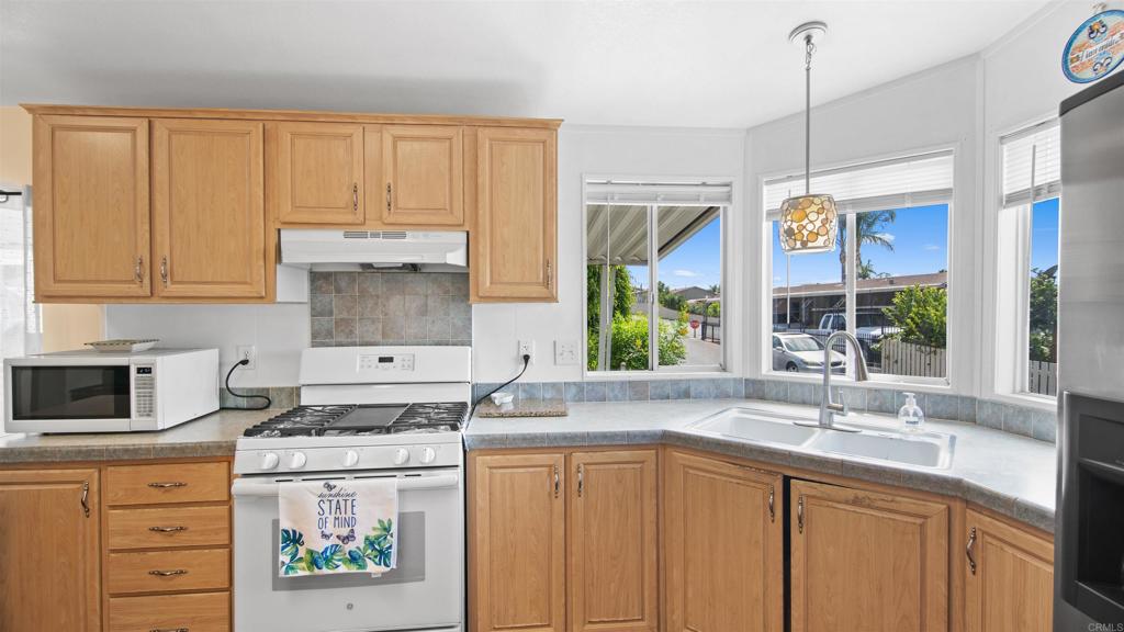 1455 Alturas Road, Unit 55 Fallbrook, CA 92028 - Photo 14 of 31 a kitchen with stainless steel appliances granite countertop a sink a stove and a microwave
