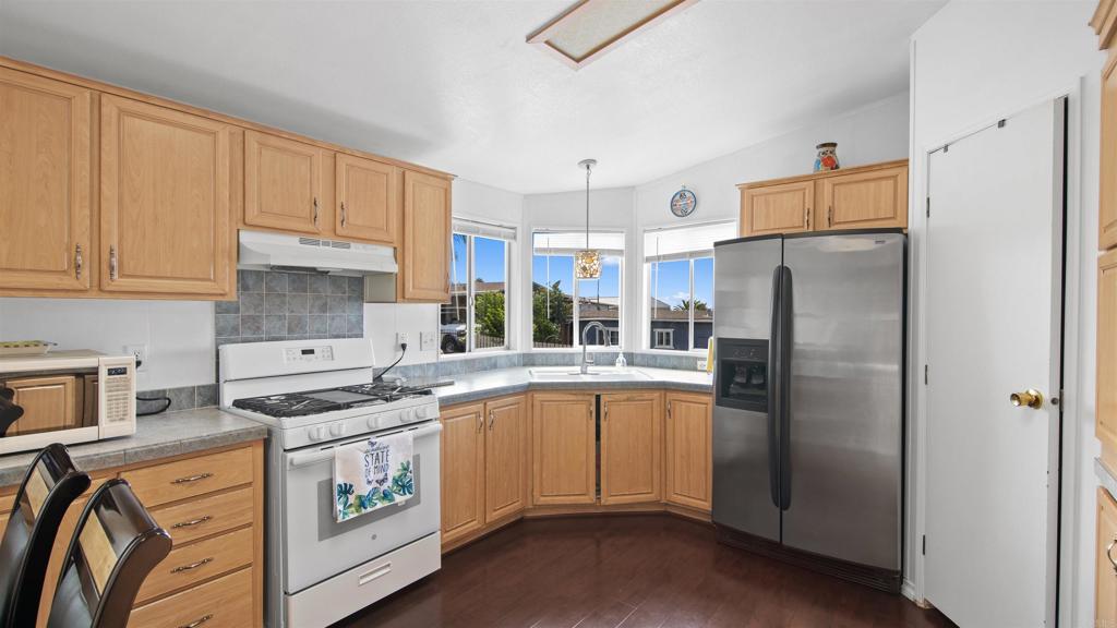 1455 Alturas Road, Unit 55 Fallbrook, CA 92028 - Photo 3 of 31 a kitchen with stainless steel appliances granite countertop a refrigerator sink and white cabinets