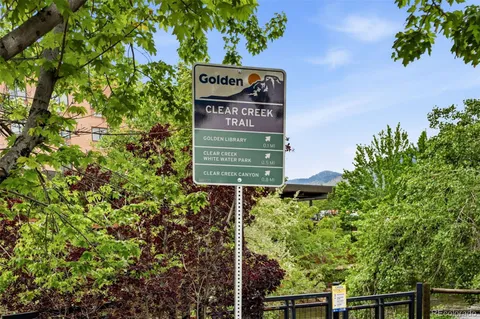 a sign that is sitting in front of a tree