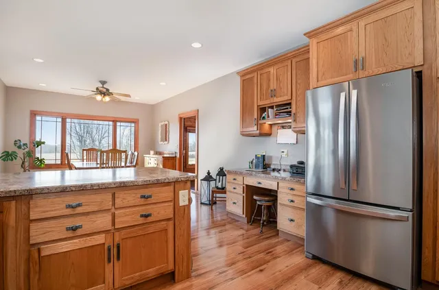 a kitchen with a refrigerator a stove a sink and a dining table with wooden floor